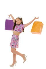 Fototapeta premium Little girl with multi-colored bags in their hands.