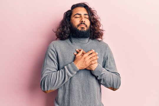 Young arab man wearing casual clothes smiling with hands on chest, eyes closed with grateful gesture on face. health concept.