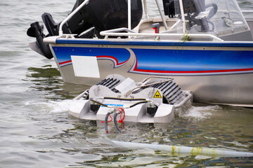 A small surface oil skimmer at a flammable petroleum liquid spill on a river