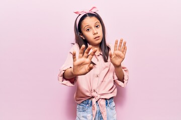 Beautiful child girl wearing casual clothes moving away hands palms showing refusal and denial with afraid and disgusting expression. stop and forbidden.