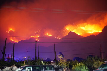 A wildfire ignited by a lightning strike during a thunderstorm burning thousands of acres of desert...