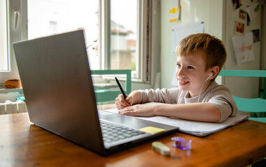 Young boy learning from home, online schooling