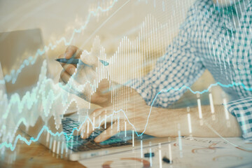 Multi exposure of forex graph with man working on computer on background. Concept of market analysis.