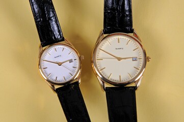 Ladies and gents quartz watches against a plain background.