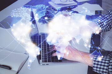 Double exposure of businessman working on laptop on background. International business hologram in front. Concept of success.