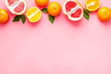 Citrus fruits on pink background top view