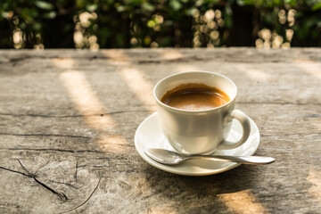 coffee cup on the wood table with sunlight
