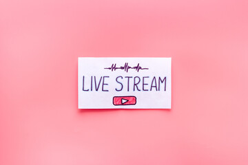 Live streaming concept - words on paper tablet on pink top view