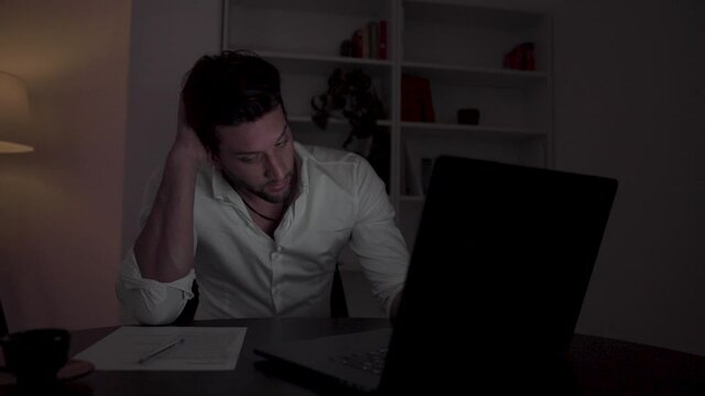 Young handsome businessman isolated working later. 
Working hard 
