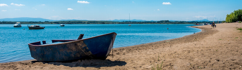 Old rusted boat on a lake beach © RITHOR