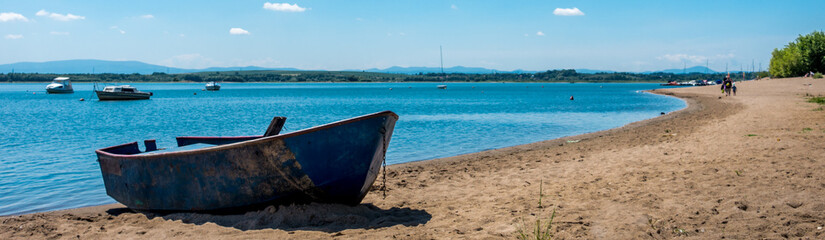 Old rusted boat on a lake beach