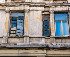 Fototapeta na wymiar Detail of an worn out old building with windows in the center of Bucharest.