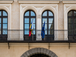 Architectural detail of a institution building in Bucharest. Romanian an European Union flags on a balcony in Romania.