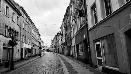 Brukowana ulica po bokach kamienic w Złotoryi