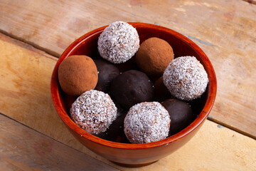 wooden bowl with chocolate truffles and energy balls, flat lay