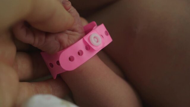 infant newborn hand arm wrist pink girl band hospital  identification wristband