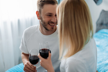 selective focus of happy man and woman holding glasses with red wine