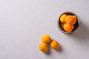 many fresh ripe orange apricots on a  clay plate on a grey background Natural fresh apricot.