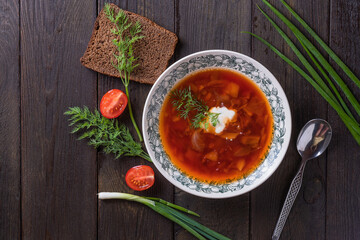 Bowl of red beet root soup borsch with white cream on wooden background, top view . Beet Root delicious soup . Traditional Ukrain food cuisine 