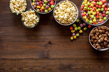Flavored popcorn on wooden background from above copy space