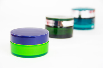 multi-colored plastic jars for care a cream