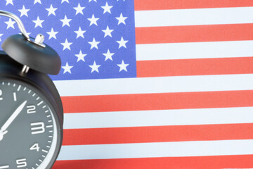 Close up of retro analog clock on USA american flag background.