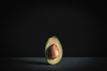 Halved avocado on black background with space for your text
