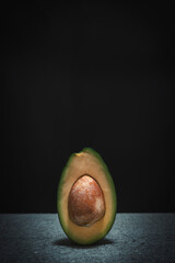 Halved avocado on black background with space for your text