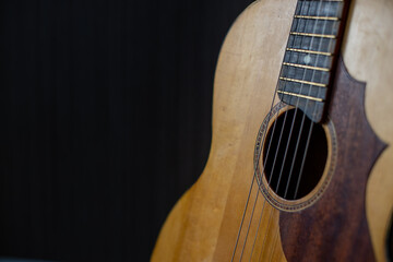 Obraz premium Acoustic guitar resting against a wooden background