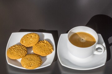 Close up view of brewed cup of coffee and cakes. Food and drinks concept.