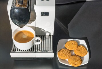 Close up view of capsule coffee machine with brewed cup of coffee. Food and drink concept.