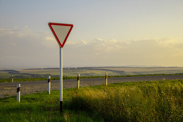 road sign at sunset day give way