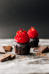 Delicious chocolate cupcakes on dark table. Tasty cupcakes with butter cream, on wooden table