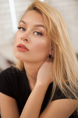 Vertical close up of a gorgeous woman with long blond hair looking to the camera sensually