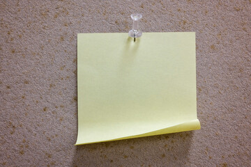 A blank yellow note on a notice board