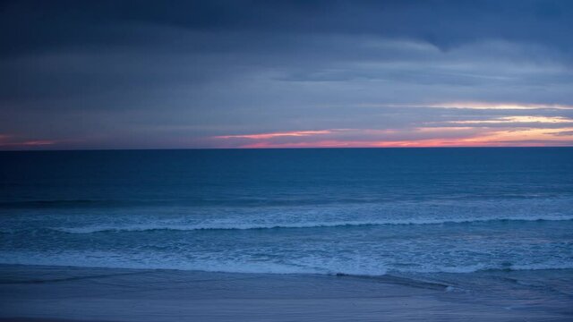 Loopable video of tide coming in and going out on beach at sunset filmed