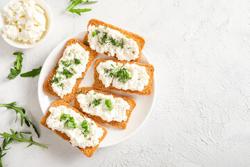 Healthy and tasty snack with crispy bread, cottage cheese and herb