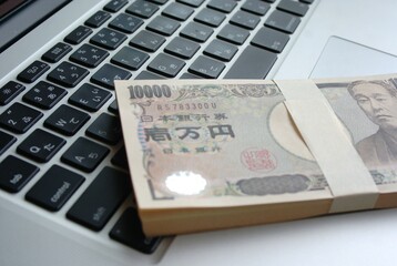 パソコンの上の100万円の札束
