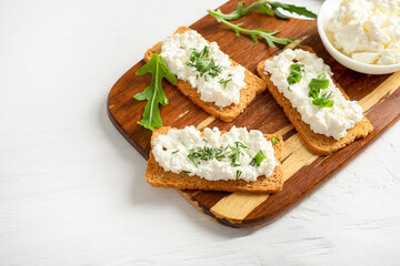 Healthy and tasty snack with crispy bread, cottage cheese and herb