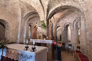 italy,Carolingian church, crypt, view of the altar of the low church, statues on the sides,arches and arcades background, central vision