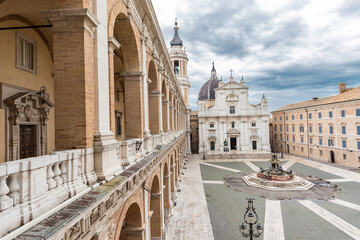 Italy, Loreto,square of Loreto with background the basilica with cloudy sky, portico to the side,...