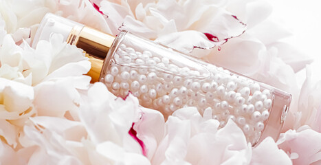 Luxurious cosmetic bottle as antiaging skincare product on background of flowers, blank label...