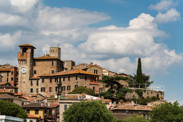 Fototapeta na wymiar View of an ancient ancient italian with towers and bell tower, blue sky and clouds background 