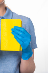 A woman in blue uniform and nitrile gloves holds a yellow rag for cleaning.