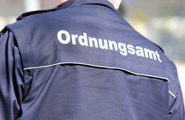 Konzept Ordnung und Sicherheit: Nahaufnahme des RÃ¼ckens eines Mitarbeiter des Ordnungsamtes in...