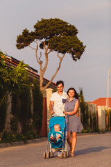 Mom, Dad and son. The family strolls through the streets of the city near houses