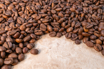 sprinkled roasted coffee beans on white and yellow marble top view
