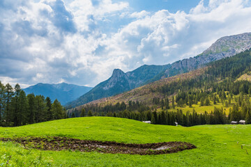 Green valley in Dolomites with heavy clouds on the background