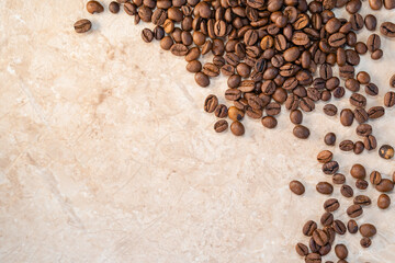 sprinkled roasted coffee beans on white and yellow marble top view