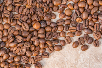 sprinkled roasted coffee beans on white and yellow marble top view